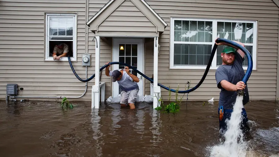 A crew removing storm flood water from a Southwest Fort Worth home